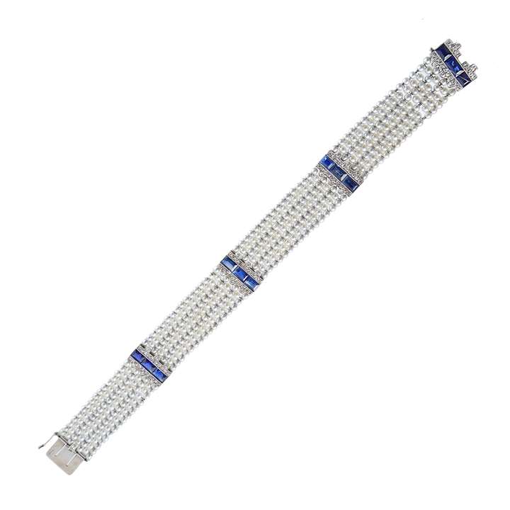 Early 20th century pearl, sapphire and diamond strap bracelet by Cartier, Paris c.1915, formed of a seven row lattice of small pearls,